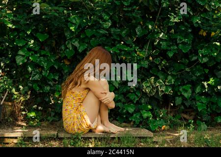 Sad woman hugging knees while sitting in car Stock Photo - Alamy