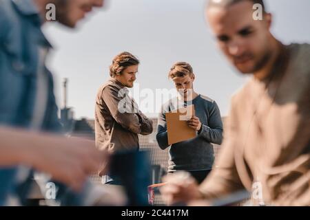 Young entrepreneurs brainstorming on a roof terrace Stock Photo