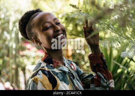 Portrait of happy young woman with eyes closed in nature