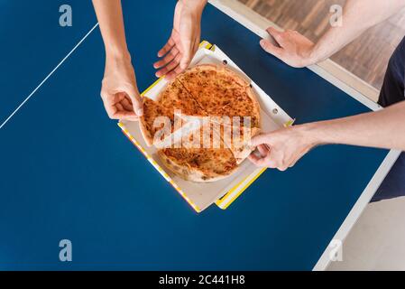 Colleagues sharing a pizza for lunch, elevated view Stock Photo
