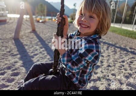Happy boy swinging on rope at Achensee, Tyrol State, Austria Stock Photo