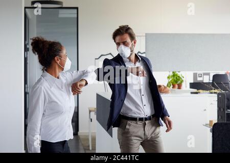 Colleagues greeting each other in office during Corona crisis Stock Photo