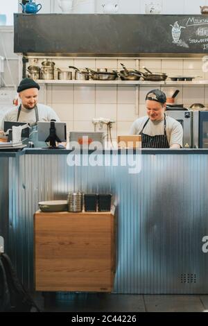 Male chefs preparing food behind kitchen counter in restaurant Stock Photo