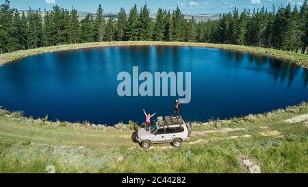 South Africa, Swellendam area, Aerial view of couple on white 4x4 driving near pond