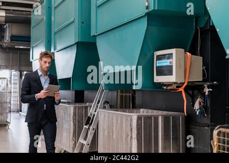 Young businessman using tablet in a factory Stock Photo