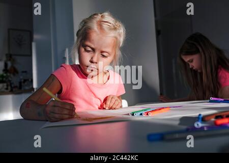 Cute girl coloring on paper at home Stock Photo
