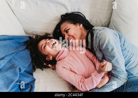 Mother and little daughter on the couch at home having fun Stock Photo