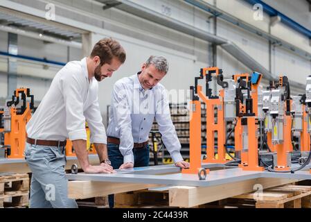 Two men looking at tablet on factory shop floor Stock Photo