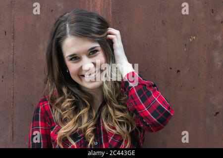 Portrait of smiling young woman wearing red plaid shirt