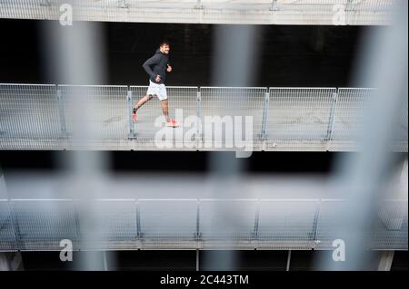 Young man running in a car park Stock Photo