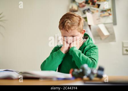 Thoughtful boy studying at home Stock Photo