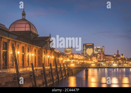 Germany, Hamburg, Illuminated Saint Pauli Piers fish market at dusk Stock Photo