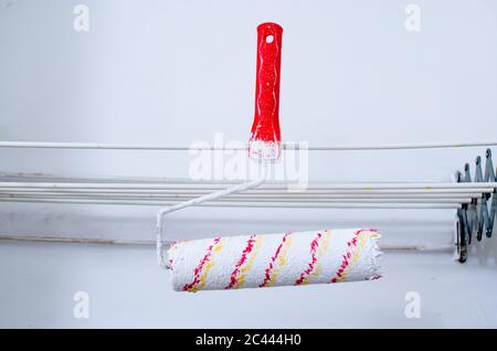 clean paint roller brush hanging on a clothes rail in bathroom Stock Photo