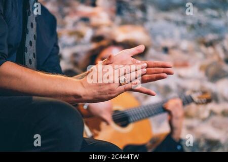 Close-up of singer clapping hands while man playing guitar in club Stock Photo