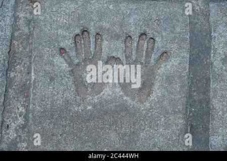 Memorable handprint of a hands in an old concrete wall. The palm is stamped on the cement floor Stock Photo