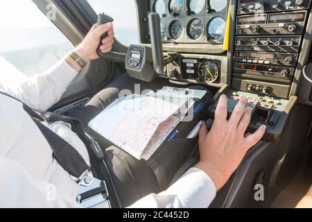 Pilot flying in sports plane, VFR chart on his lap Stock Photo