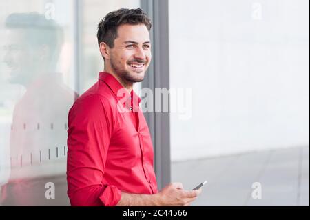 Smiling businessman using smartphone Stock Photo