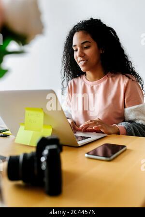 Young woman working from home using laptop Stock Photo