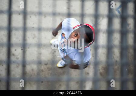 Young jogger with red headphones standing under grid and looking at camera Stock Photo