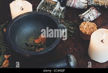 Kitchen witchery - making magickal spice blend for a spell. Dried herbs and spices mixed in mortar ready to be blended with pestle Stock Photo