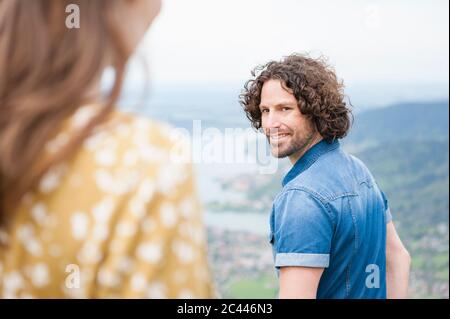 Smiling handsome man looking back at woman Stock Photo