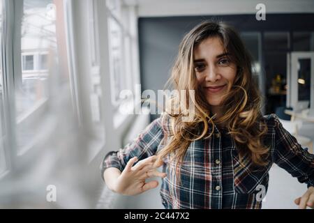 Portrait of smiling young woman dancing in a loft Stock Photo