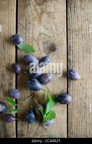 Fresh plums on wooden surface Stock Photo