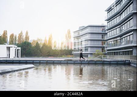 Young man with headphones jogging in the city Stock Photo