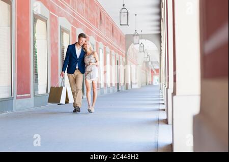 Romantic couple with shopping bags walking in corridor Stock Photo