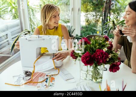 Woman with friend sewing face masks at home Stock Photo