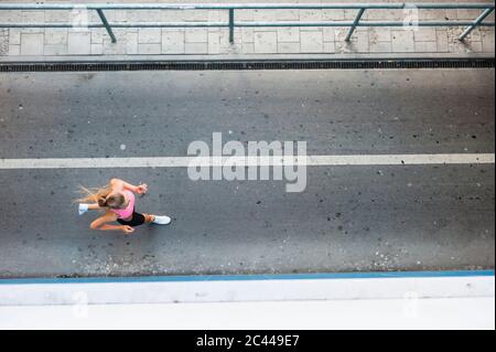 Female jogger on street in the city, from above Stock Photo