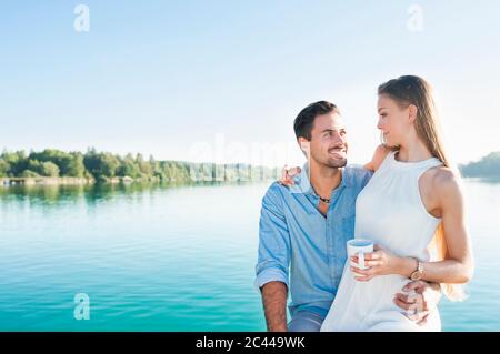 Young couple relaxing in front of a lake Stock Photo