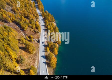 Switzerland, Canton of Grisons, Saint Moritz, Drone view of highway stretching along shore of Lake Sils in autumn Stock Photo