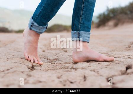 Woman's feet on dry soil, Sardinia, Italy
