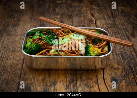 Lunch box of soba noodles with bok choy, broccoli, soy sauce and black sesame seeds Stock Photo