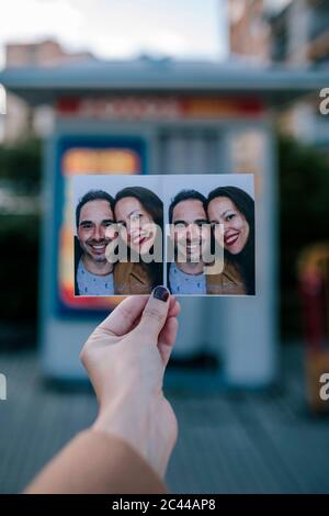 Woman's hand holding photograph outside photo booth Stock Photo