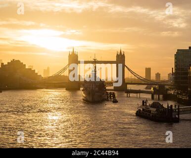 LONDON, UK - 11TH MARCH 2015:  A view towards Tower Bridge at sunrise across the River Thames. HMS Belfast can be seen in front of it. Stock Photo