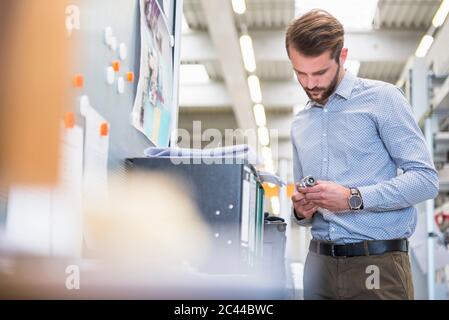 Man examining workpiece in a factory Stock Photo