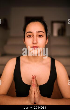 Close-up of confident woman meditating in prayer position at home Stock Photo