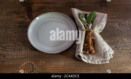Set of cutlery knife, spoon, fork with linen napkin on the plate. Stock Photo