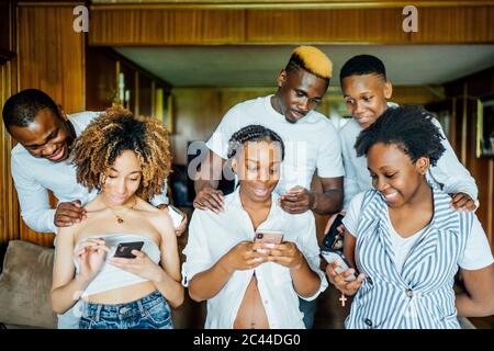 Family and friends using cell phones at home Stock Photo