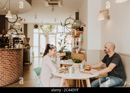 Smiling man and woman sitting at table in a coffee shop