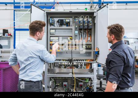 Two technicians working on circuit in factory Stock Photo