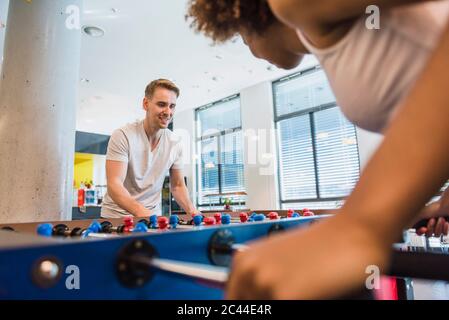 Young business people playing football in their lunch break Stock Photo