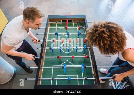 Young business people playing football in their lunch break Stock Photo