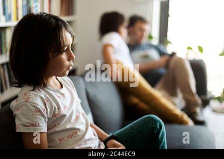 Boy sitting on couch at home watching television Stock Photo