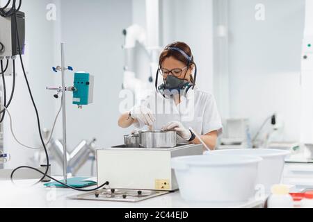 Confident mature female technician doing research in lab Stock Photo