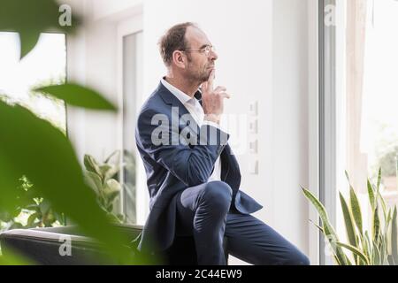 Pensive businessman looking out of window Stock Photo