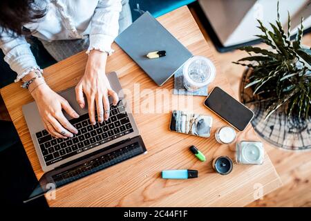 Crop view of young woman working on laptop at home, top view Stock Photo