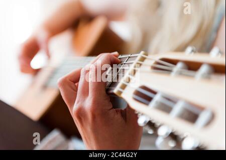 Hand of woman playing guitar, close-up Stock Photo